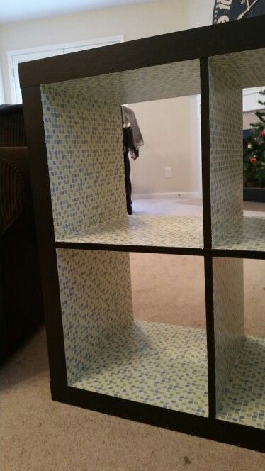 a black and white display case sitting on top of a carpeted floor next to a christmas tree