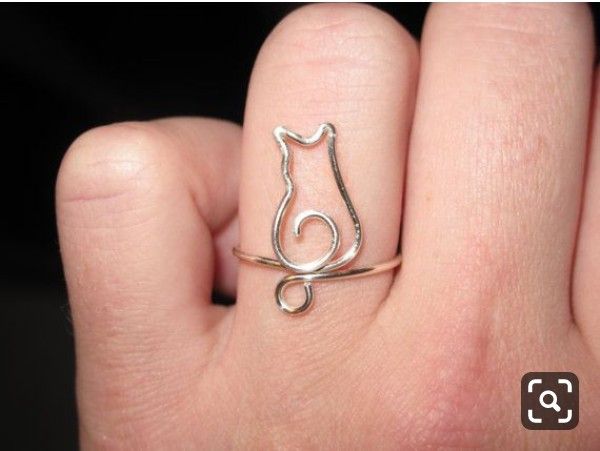 a person's hand with a cat ring on it