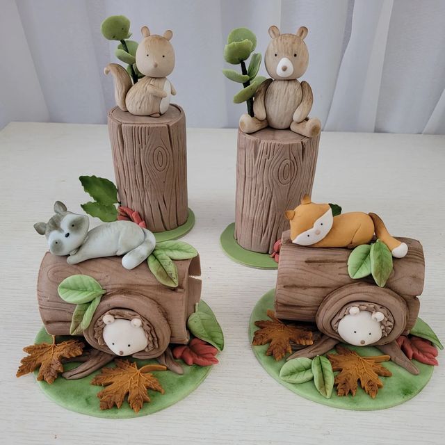 there are three small figurines made to look like animals on top of logs