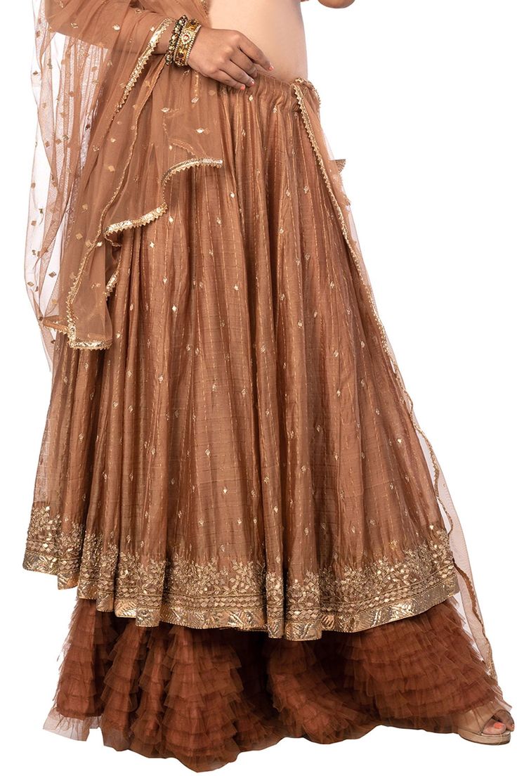 Brown layered lehenga with all-over gota floral motifs. Comes with blouse and net dupatta.
Component: 3
Pattern: Embroidery
Type Of Work: Gota
Neckline: V neck
Sleeve Type: Cap
Fabric: Chanderi and Net
Color: Brown
Other Details: 
Blouse with pleated detail on the hem
Embellished dupatta with lace border
Lehenga with tie up and tassels on the side
Closure: Side zip
Occasion: Wedding - Aza Fashions V Neck Lehenga, Chanderi Lehenga, Layered Lehenga, Net Embroidery, Pattern Embroidery, Net Dupatta, Lace Border, Floral Motifs, Set For Women