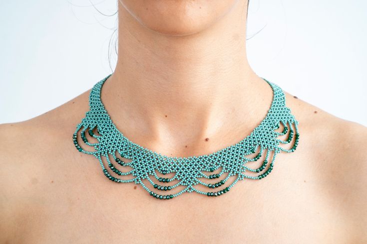 a woman wearing a green crochet necklace