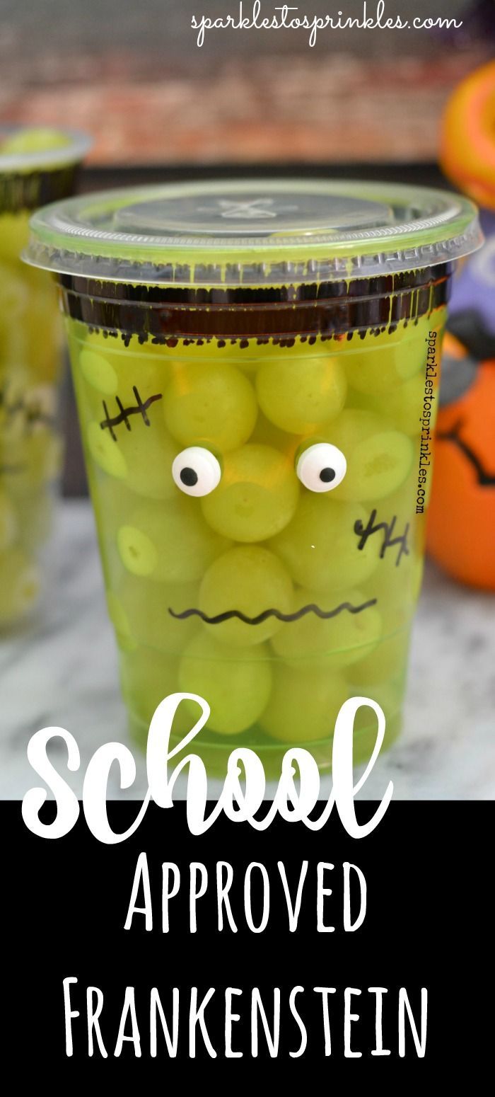 a plastic cup filled with green halloween candies and the words school approved in front of it