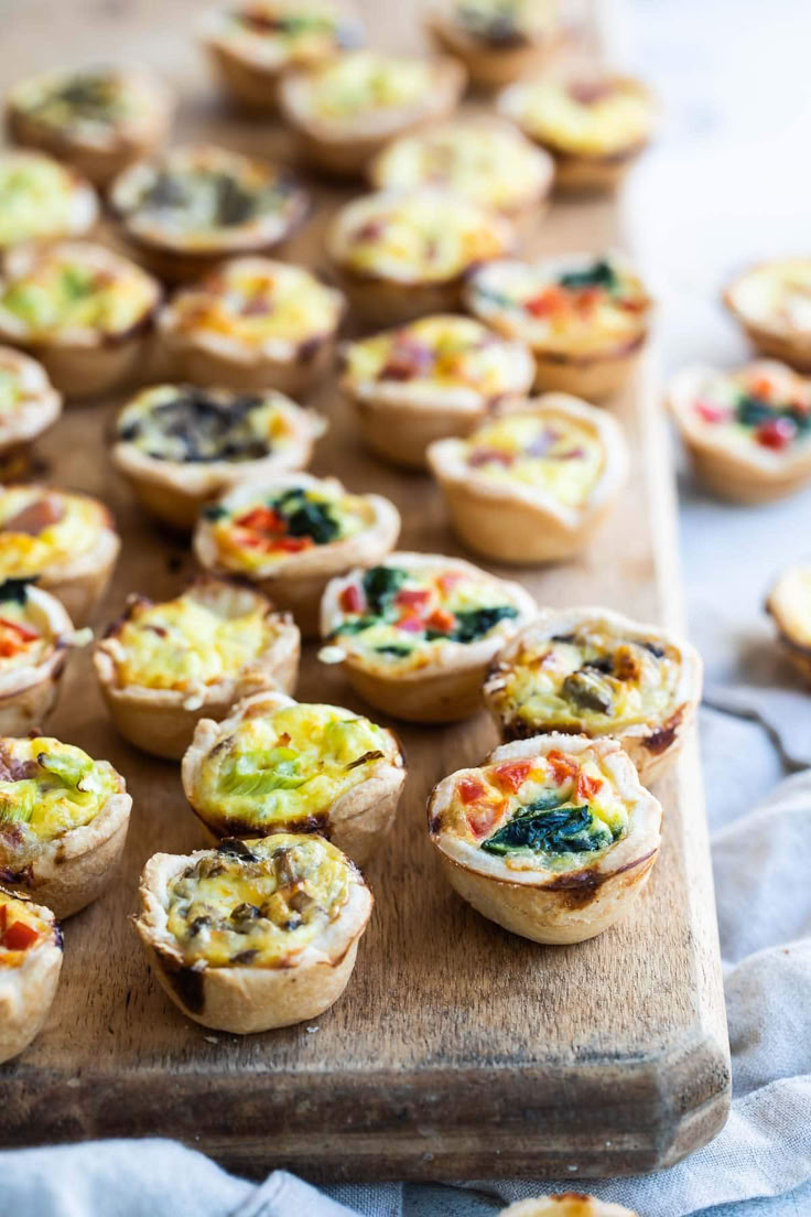 mini quiche cups are arranged on a cutting board