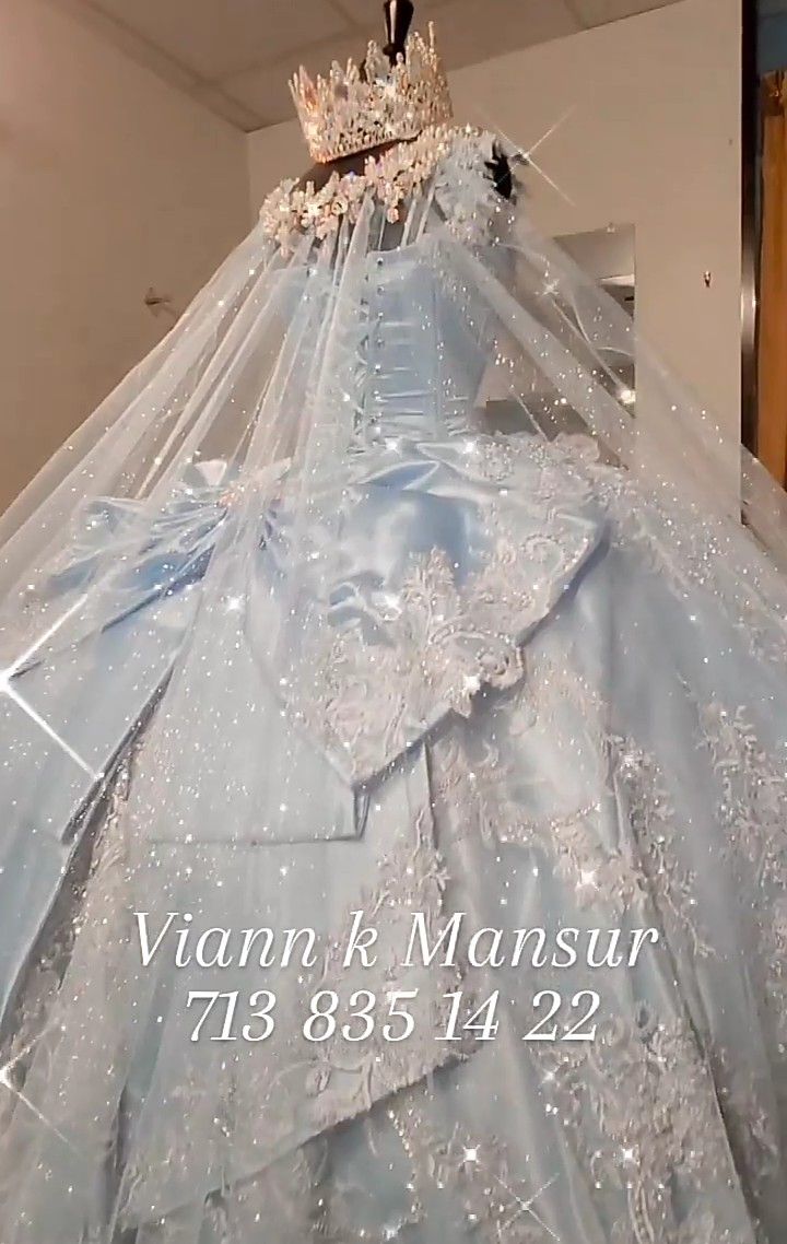 a wedding dress with a veil and tiara on display