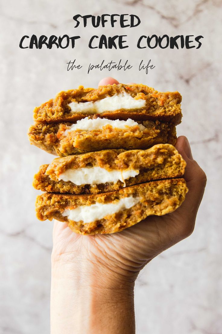 someone holding up some carrot cake cookies with icing on them and the words stuffed carrot cake cookies above it