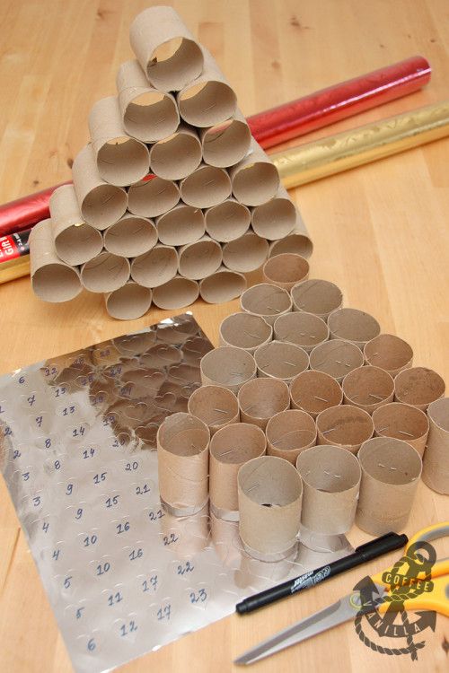 several rolls of toilet paper are arranged on a table with scissors, tape and pencils