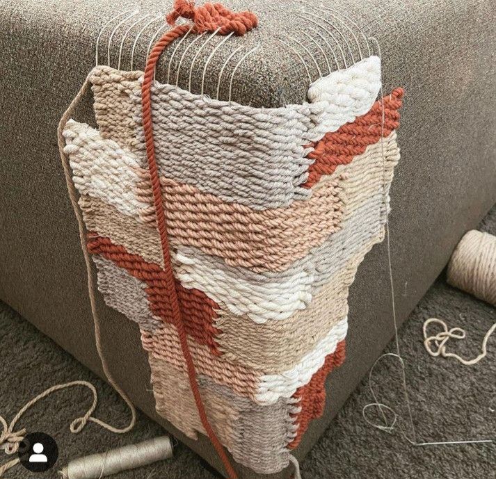 a close up of a couch with yarn on the floor next to it and an orange string