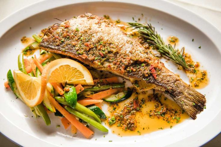 a white plate topped with fish and veggies