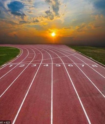 the sun is setting over a running track