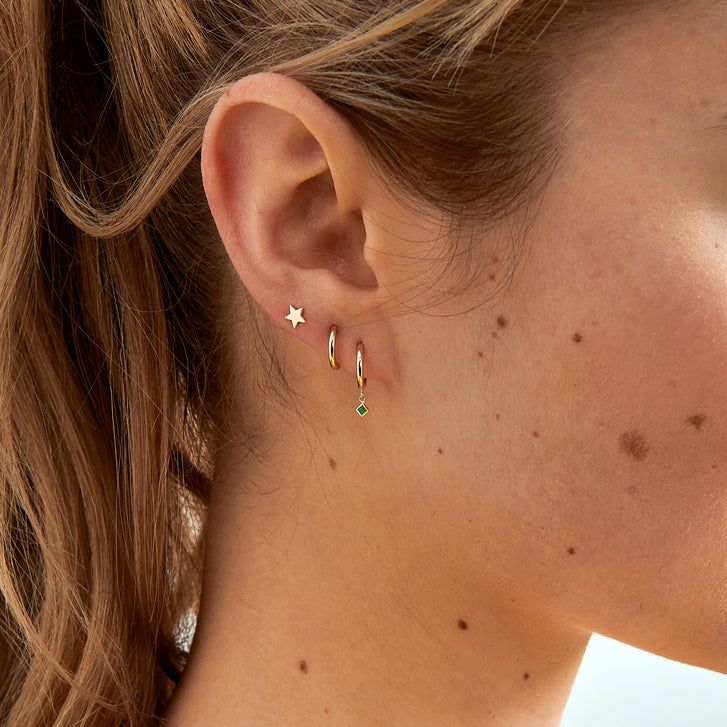 a close up of a woman's ear with small stars on the back of it