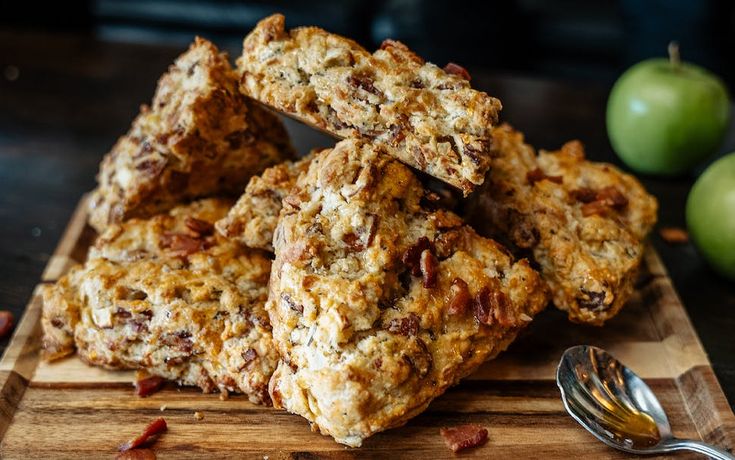 several pieces of granola sitting on top of a cutting board next to an apple