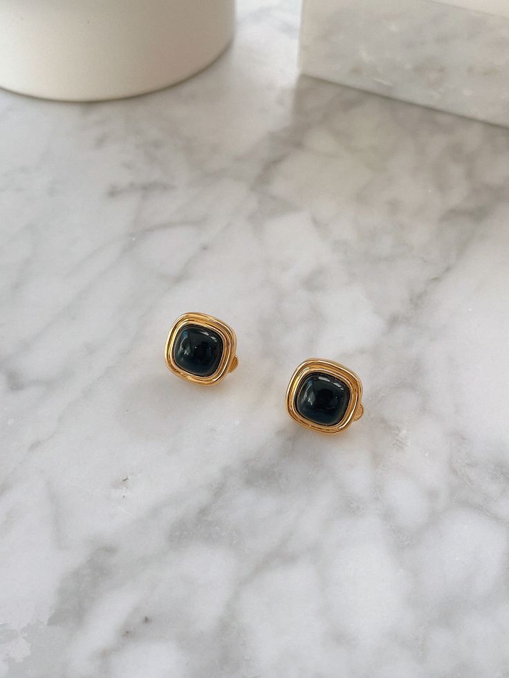 The allure of black onyx, a stone steeped in the symbolism of strength and protection, finds its form in the "Nocturne" Square Clip Earrings. These earrings embody a quiet confidence, balancing the deep, velvety hue of the onyx with the warmth of 18k Gold Vermeil. Crafted to frame the face with elegance, they offer a refined yet bold statement for both day and night. Materials: Natural black onyx, set in 18k Gold Vermeil over sterling silver. Charm Dimensions: 15mm x 15mm, offering a structured, Black Gemstone Drop Earrings, Gold Onyx Earrings, Nickel-free Black Onyx Earrings, Classic Black Clip-on Earrings For Gift, Classic Black Clip-on Earrings As Gift, Minimalist Tarnish Resistant Black Earrings, Minimalist Black Tarnish Resistant Earrings, Formal Black Onyx Earrings, Formal Black Obsidian Jewelry