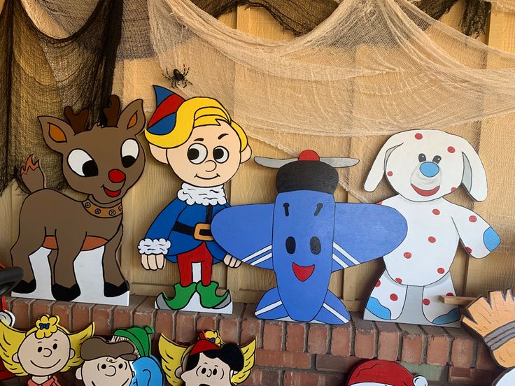 there are many cartoon characters on the brick wall and in front of them is a dog