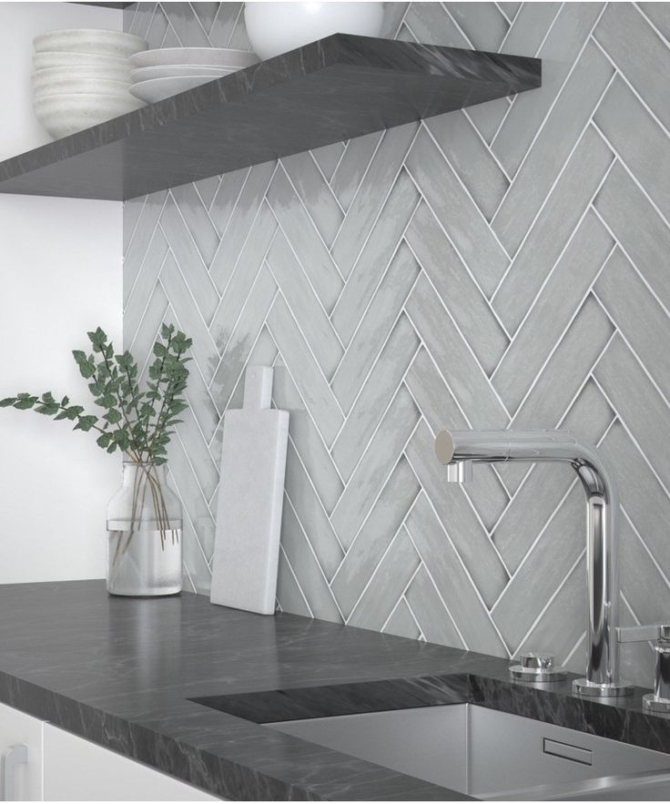 a kitchen counter with a sink and some shelves above it that have vases on them