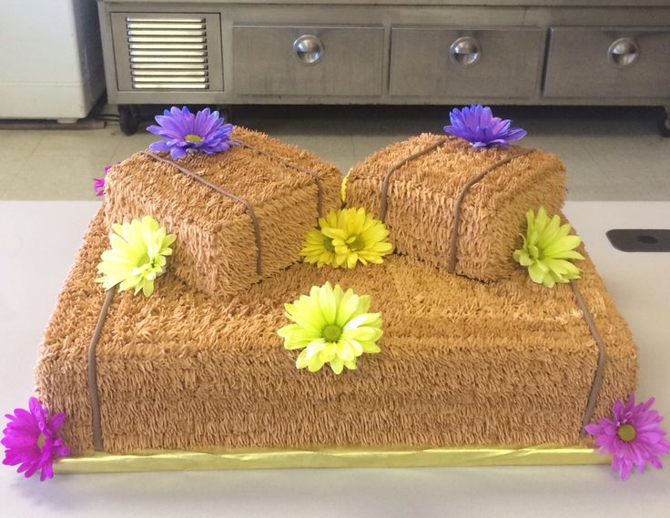 a cake made to look like couches with flowers on the top and one that is rolled up