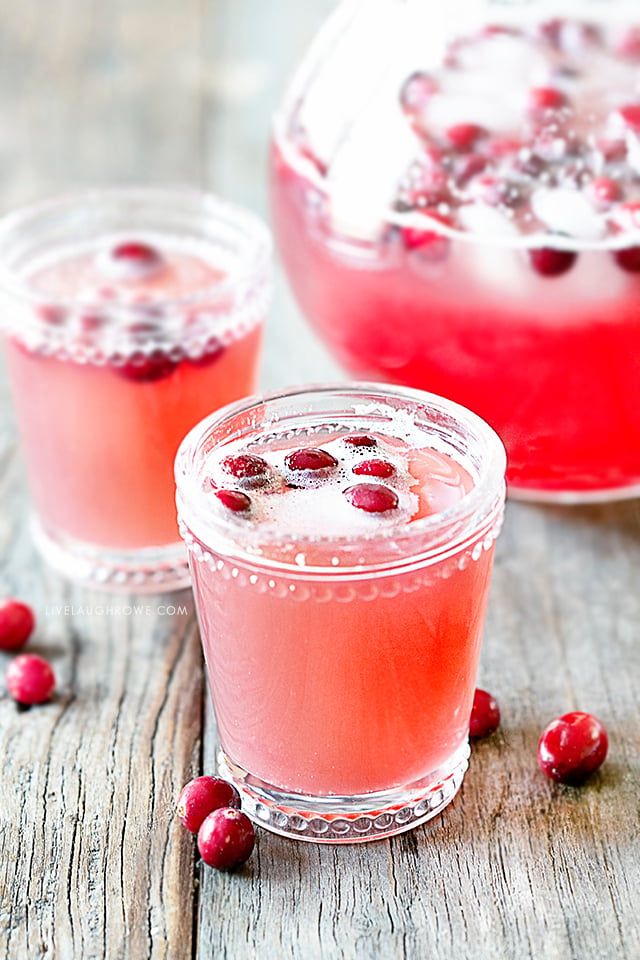 two glasses filled with cranberry punch on top of a wooden table