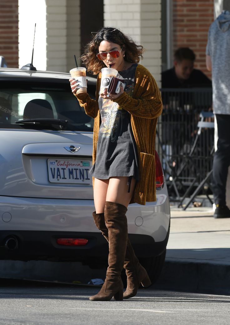 a woman is walking down the street drinking coffee