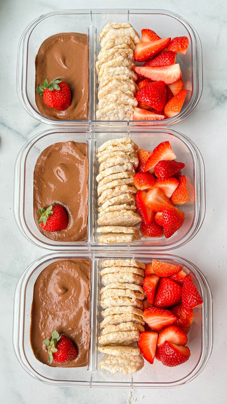 four plastic containers filled with different types of food on top of a white countertop