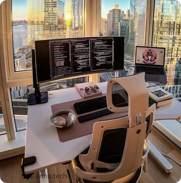 a computer desk with two monitors and a keyboard on it in front of a window