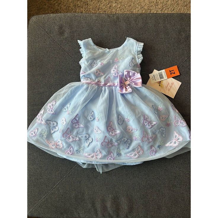 Make Your Little Girl Feel Like A Butterfly With This Jona Michelle Party Dress In Size 2t. The Dress Features A Crew Neck And Button Closure, With A Sleeveless Design That Is Perfect For Formal Occasions Like Weddings And Parties. The Blue Dress Is Made Of Polyester With A Tulle-Like Overlay, And Has Embroidered Butterfly Accents That Give It A Unique Touch. This Special Occasion Dress Has A Lined Interior, With Ruffled Trim Around The Sleeve And A Tie In The Back For Added Style. The Dress Als Playful Blue Princess Dress For Summer, Fitted Light Blue Princess Dress For Spring, Cute Spring Princess Dress For Play, Cute Blue Princess Dress For Summer, Playful Princess Dress For Spring Playtime, Fitted Light Blue Princess Dress For Summer, Light Blue Fitted Princess Dress For Summer, Cute Sleeveless Light Blue Princess Dress, Light Blue Sleeveless Birthday Dress