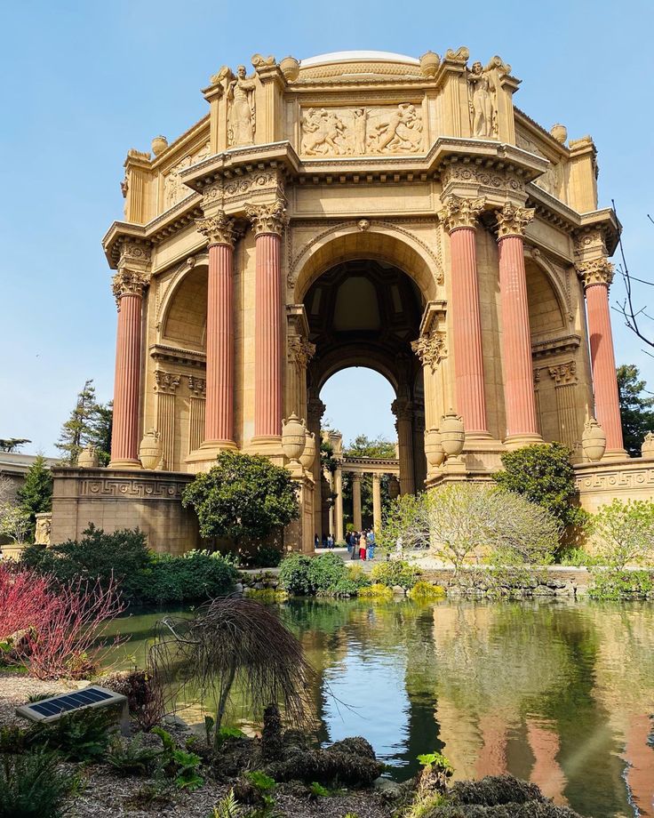 an ornate building surrounded by greenery next to a body of water