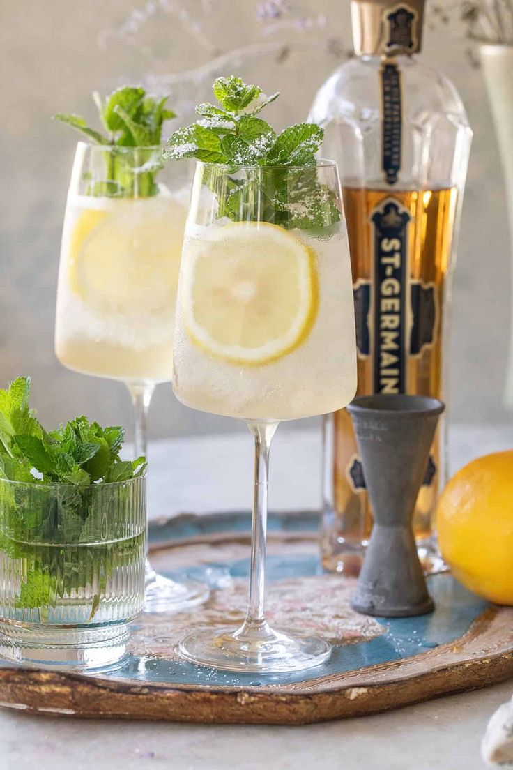 two glasses filled with lemonade and mint on a tray