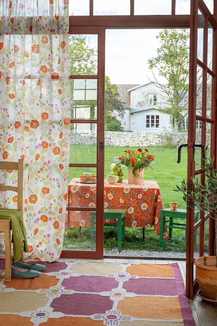 an open door leading to a patio with a table and chairs in the middle of it