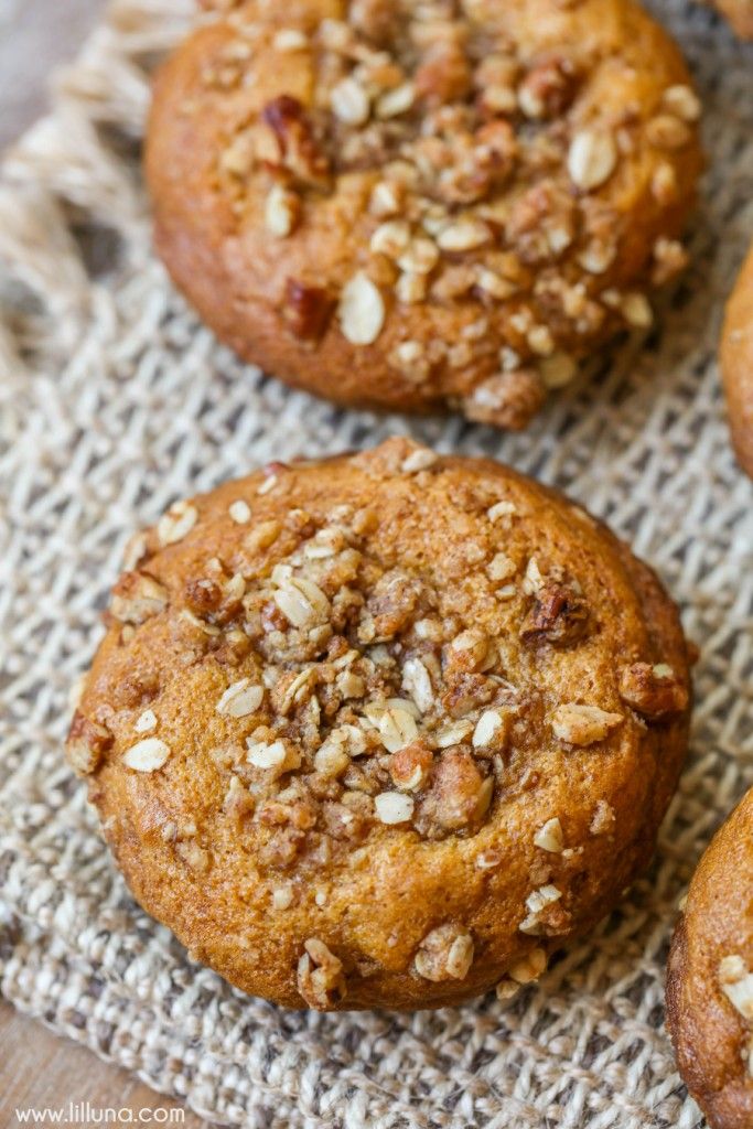 three muffins with nuts on top sitting on a cloth