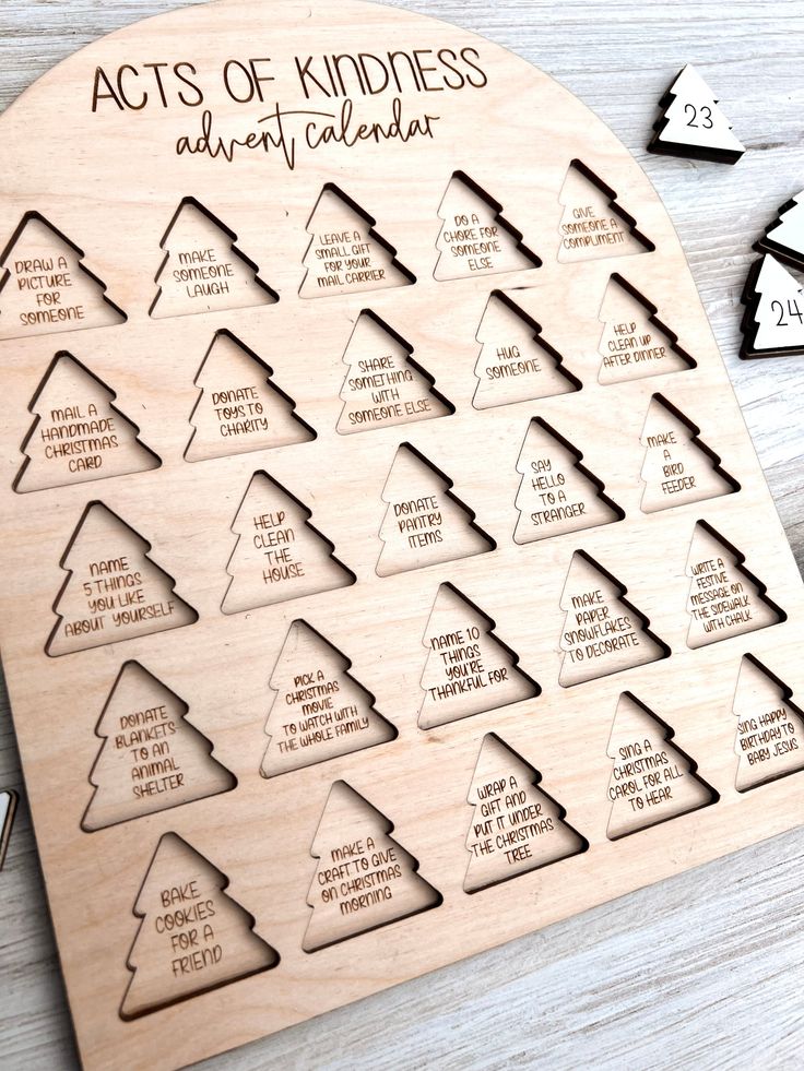 a wooden calendar with the words acts of kindness and christmas trees in different languages on it