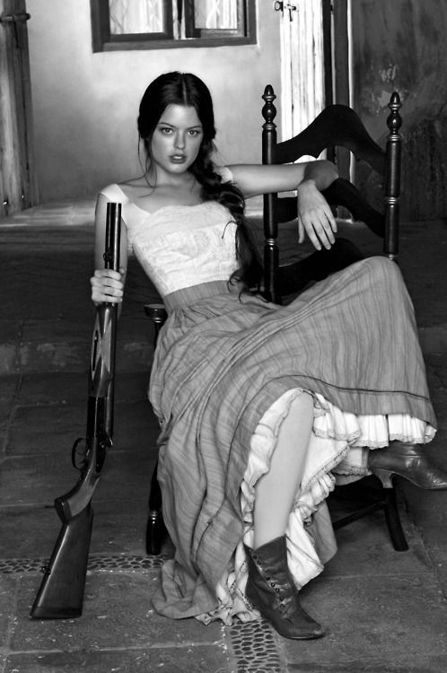 black and white photograph of a woman sitting on a chair with an umbrella in her hand