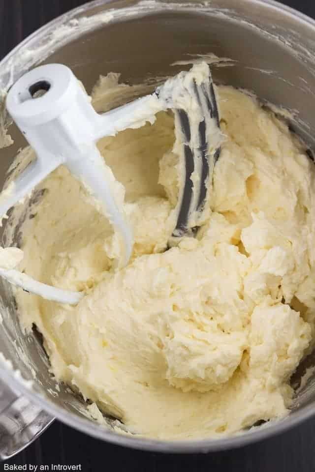 a mixer filled with cream sitting on top of a table