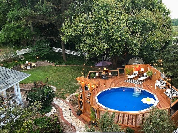 an aerial view of a backyard with a pool and deck