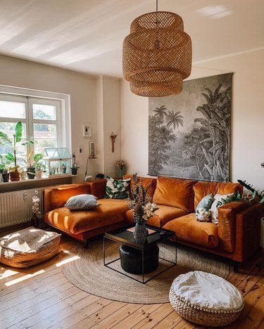 a living room filled with furniture and a large painting on the wall above it's windows