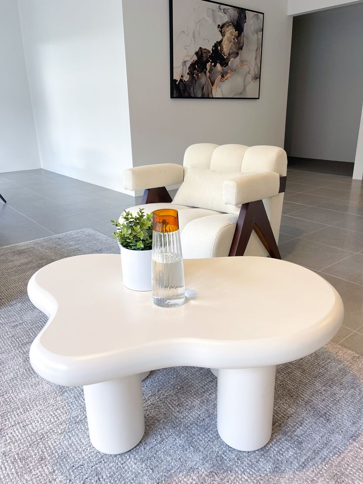 a white coffee table sitting on top of a carpeted floor next to a chair