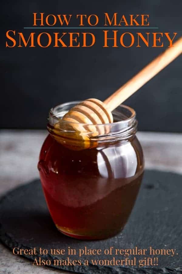 a jar filled with honey sitting on top of a black plate next to a wooden spoon