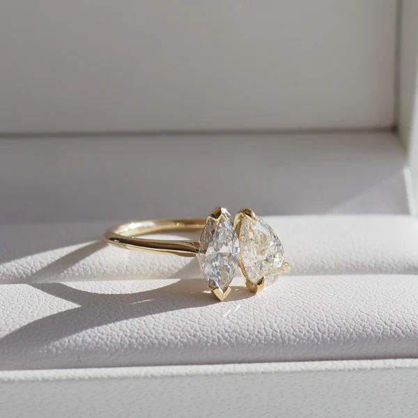 two pear shaped diamond engagement rings in a box