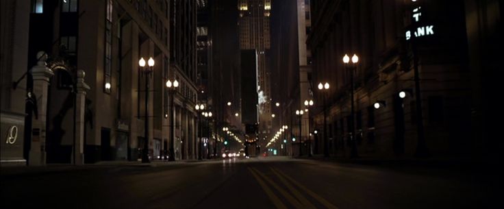 an empty city street at night with tall buildings