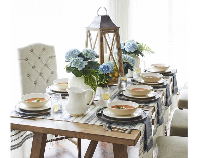 a dining room table is set with plates and bowls