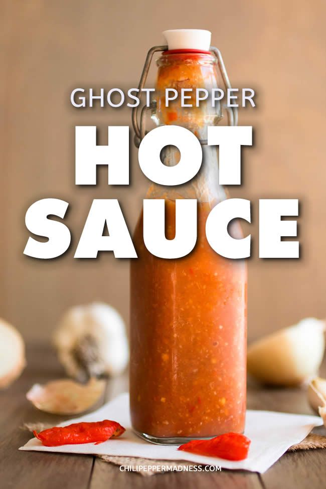 hot sauce in a glass bottle with the words ghost pepper hot sauce above it on a wooden table