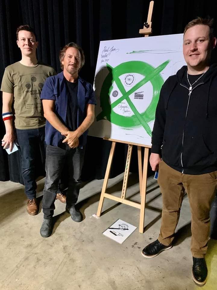 three men standing in front of a white board