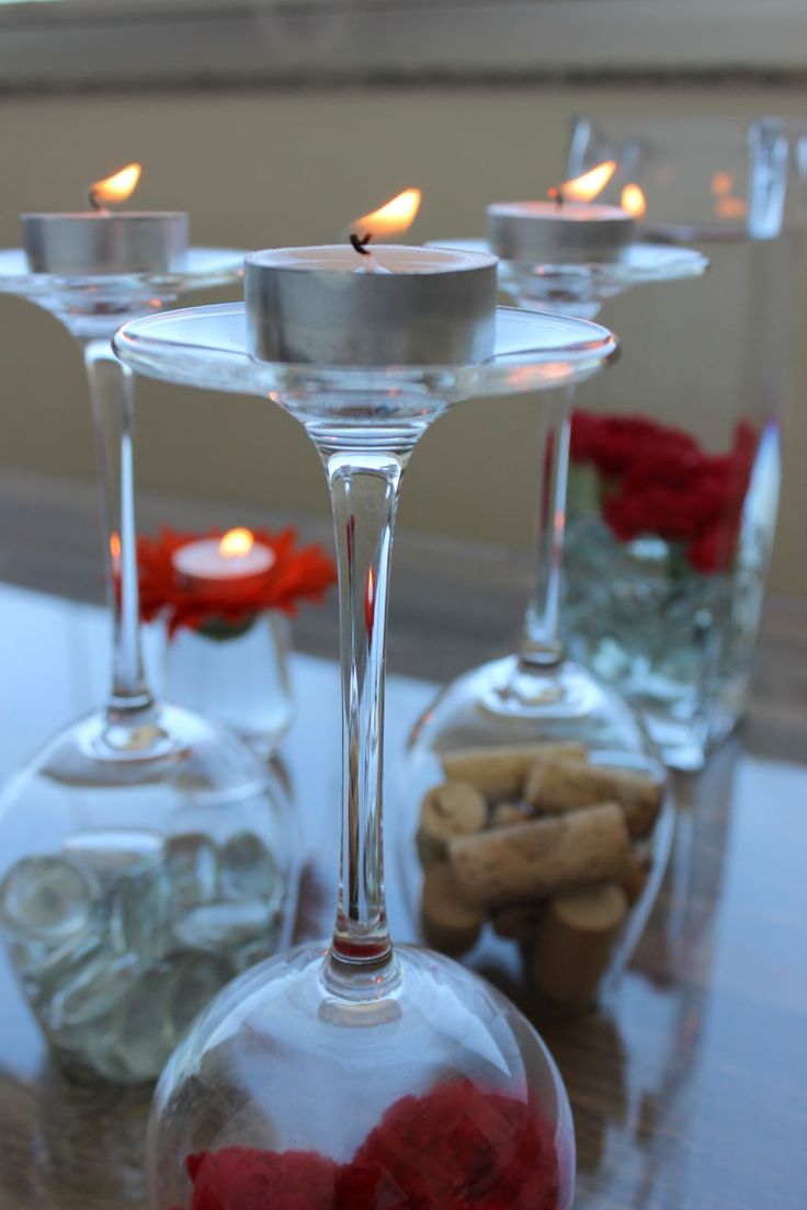 several wine glasses with candles in them sitting on a table