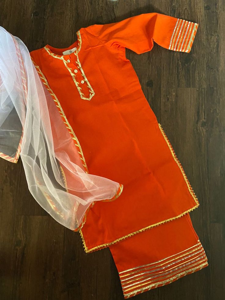 This orange kurta palazzo has been a dream come true for all the mums out there who have been wanting to get their babies dressed in ethnic yet comfortable wear.  Fabric- cotton Colour - orange Sizes - 6months to 5years (MTO) Approx measurements in inches- Photo attached. Care Guide - Dry clean only Disclaimer - pl check measurements before ordering as exchange and refunds based on measurements is not possible. Colours can vary due to screen settings. Orders outside the UK or India will be poste Traditional Orange Salwar Kameez For Navratri, Festive Orange Kurta With Zari Work, Festive Orange Set With Dupatta, Orange Gota Work Salwar Kameez For Festivals, Orange Salwar Kameez With Gota Work For Festivals, Traditional Orange Salwar Kameez For Eid, Orange Straight Kurta Sharara For Festive Occasions, Orange Salwar Kameez For Navratri, Orange Sharara With Dabka For Eid