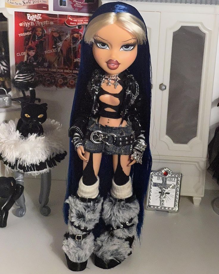 a doll is dressed in black and white with furs on her legs, holding a knife