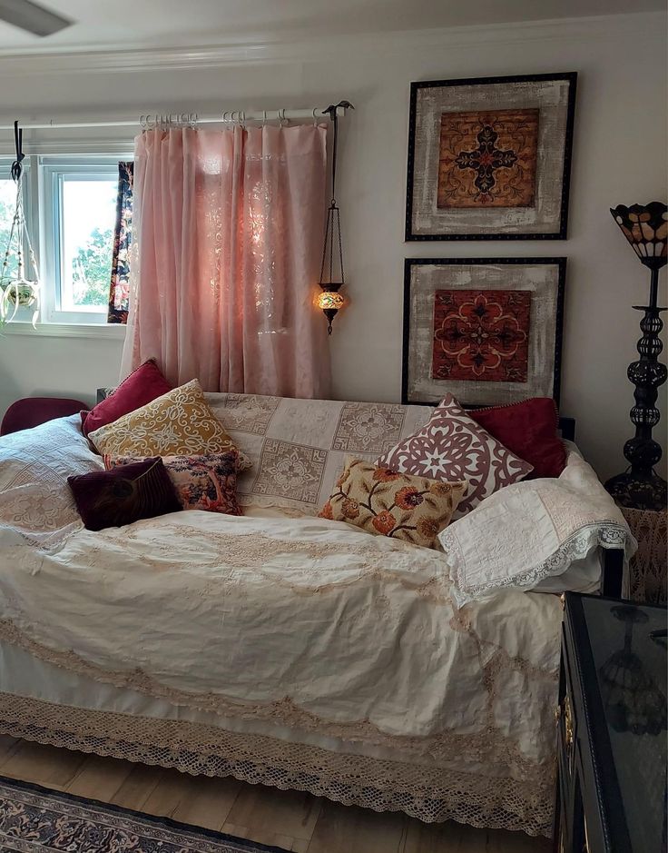 a living room filled with furniture and pictures hanging on the wall above it's windows