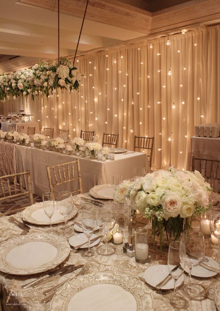 the tables are set with white flowers and place settings for an elegant dinnereon party