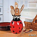 a ladybug jar with utensils and spoons in it sitting on a table