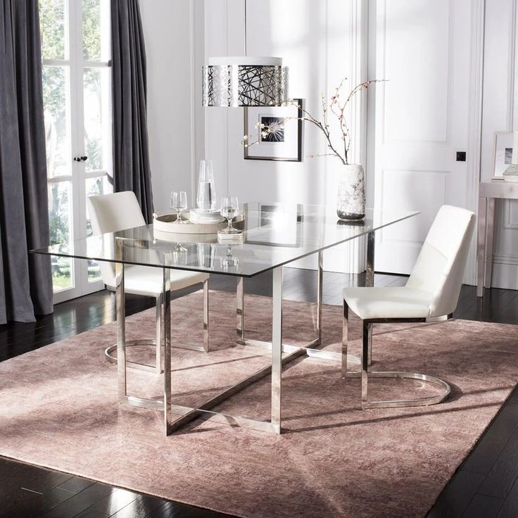 a glass dining table with white chairs and a rug on the floor in front of it