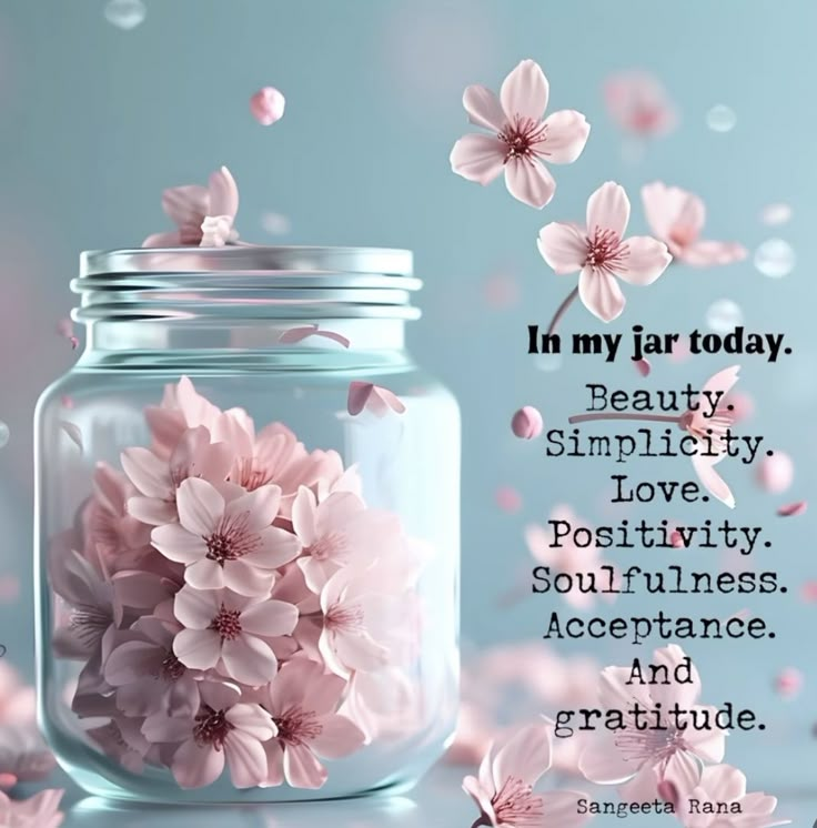 a jar filled with pink flowers on top of a table