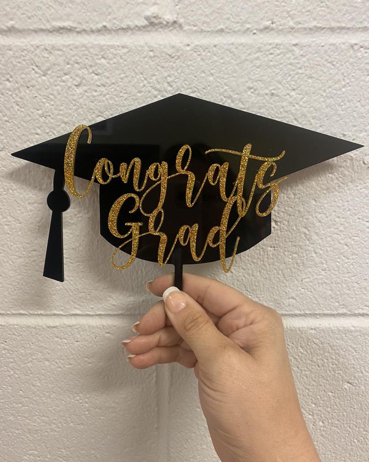 someone holding up a graduation cap that says congrats grad