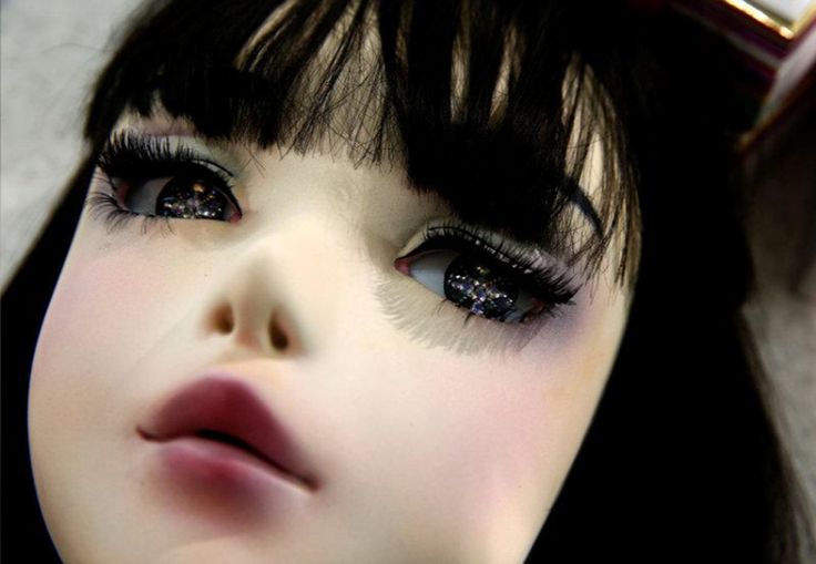 a close up of a doll's face with long eyelashes